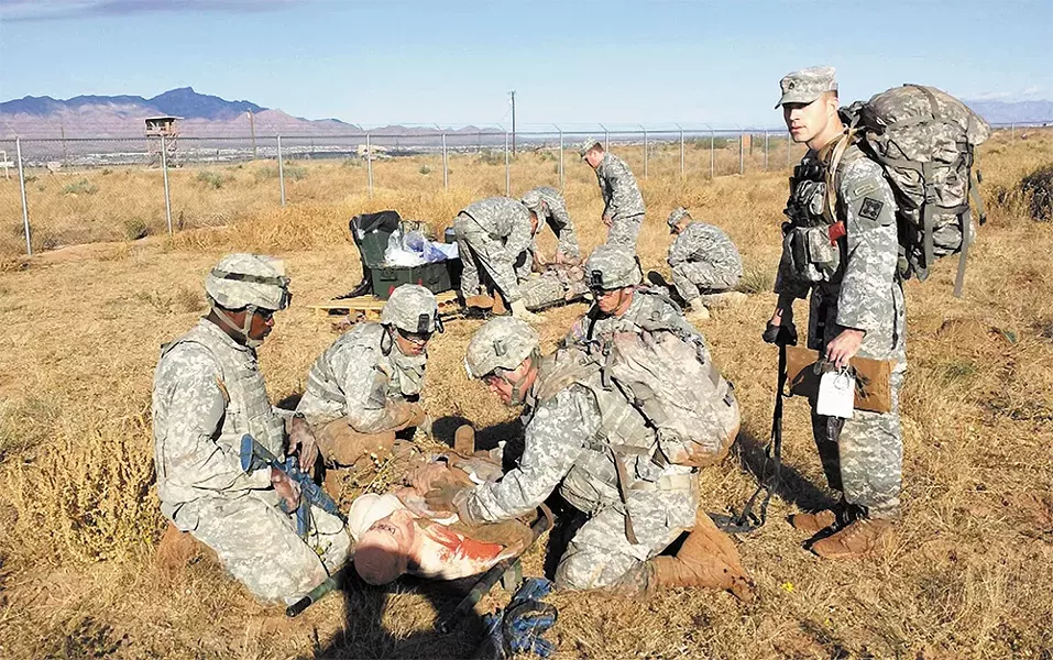 Adam Sahlberg (above right) evaluates a team of medics as they evacuate and treat a mannequin with life-threatening injuries during a simulated "care under fire" scenario last November in the high desert outside Fort Bliss, near El Paso, Texas.