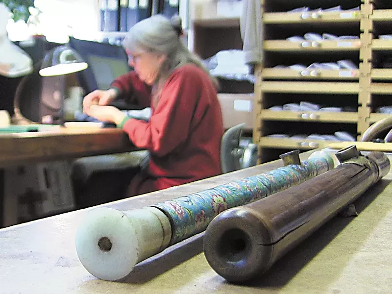 An enamel-decorated opium pipe, recently donated to the University of Idaho, rests next to one made of bamboo as Priscilla Wegars catalogs other opium artifacts. - ERIC FRANCAVILLA