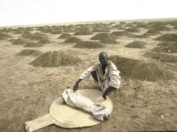 An Ethiopian refugee, in 1984, with a shrouded body of a child, a victim of hunger/drought, at a refugee camp in Sudan. - WILLIAM F. CAMPBELL/GETTY IMAGES