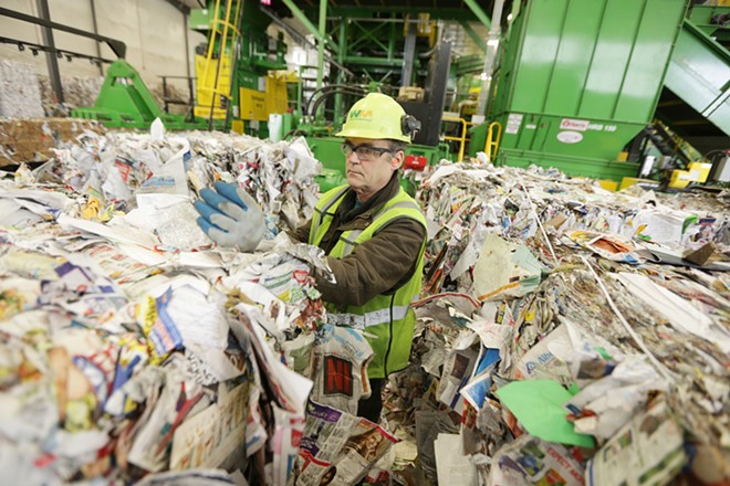 Rick McHenry removes items that don't belong from a bale of paper at Waste Management's SMaRT Center in Spokane on April 10. - YOUNG KWAK