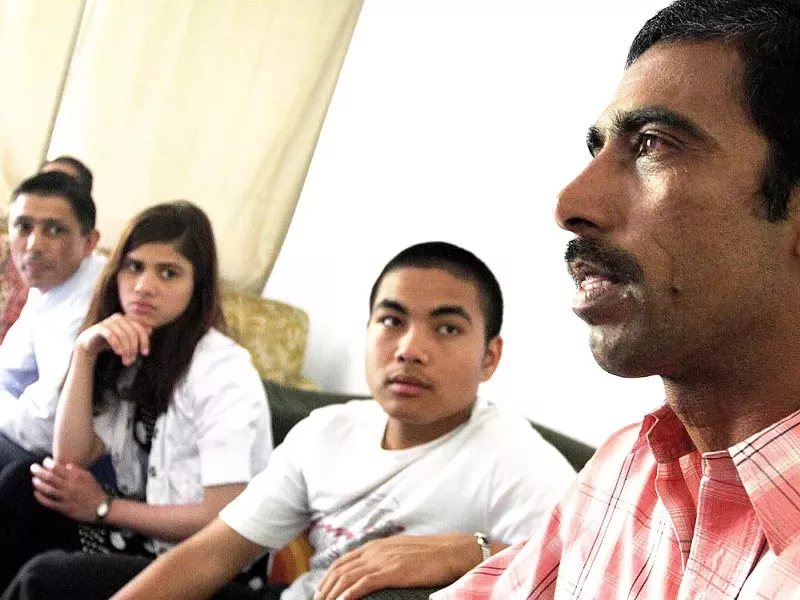 Bhim Dhakal, right, speaks about his missing son, Krishna, who disappeared on June 11 along with two other Bhutanese refugees. - YOUNG KWAK