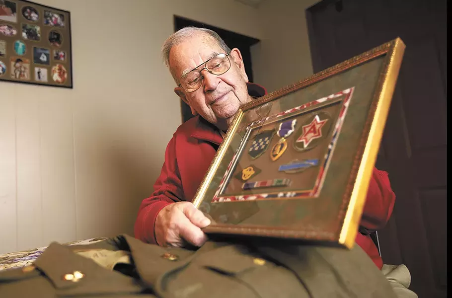 Bill Akers, a private first class during World War II, with his uniform and awards for service. - YOUNG KWAK