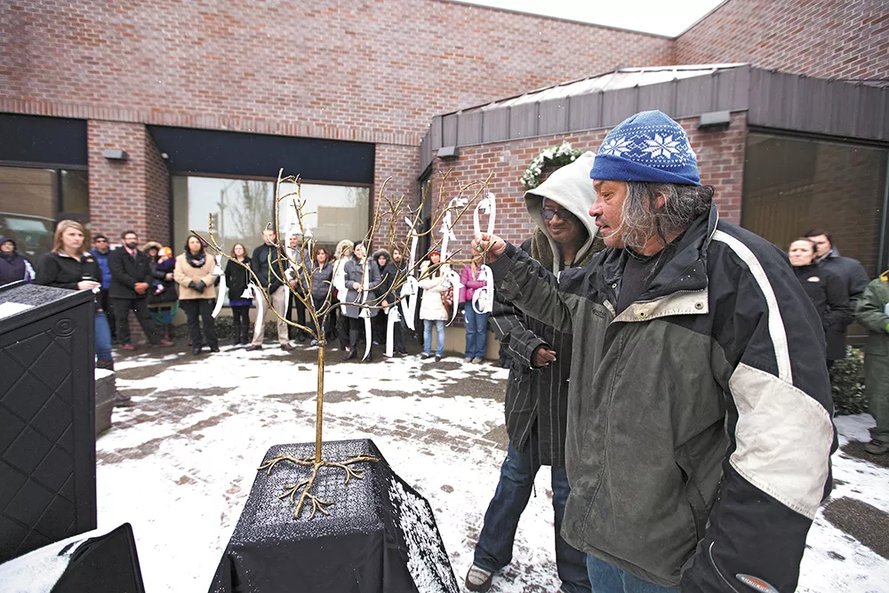 Bruce Geer, right, places a bell representing one of the 39 local homeless people who died this year. - YOUNG KWAK