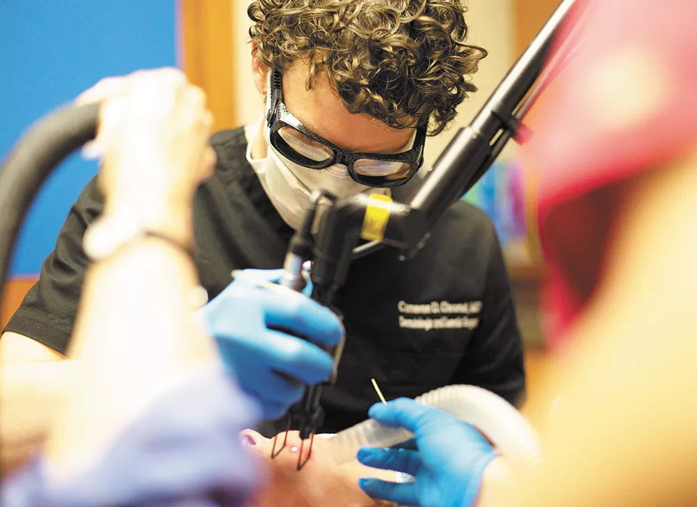 Cameron Chesnut, MD, begins work with the laser to reduce fine lines, wrinkles or sun spots. - YOUNG KWAK