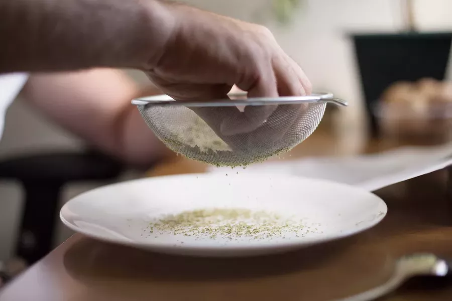 Co-Owner Wesley Tuttle uses a strainer to break apart hash. - YOUNG KWAK