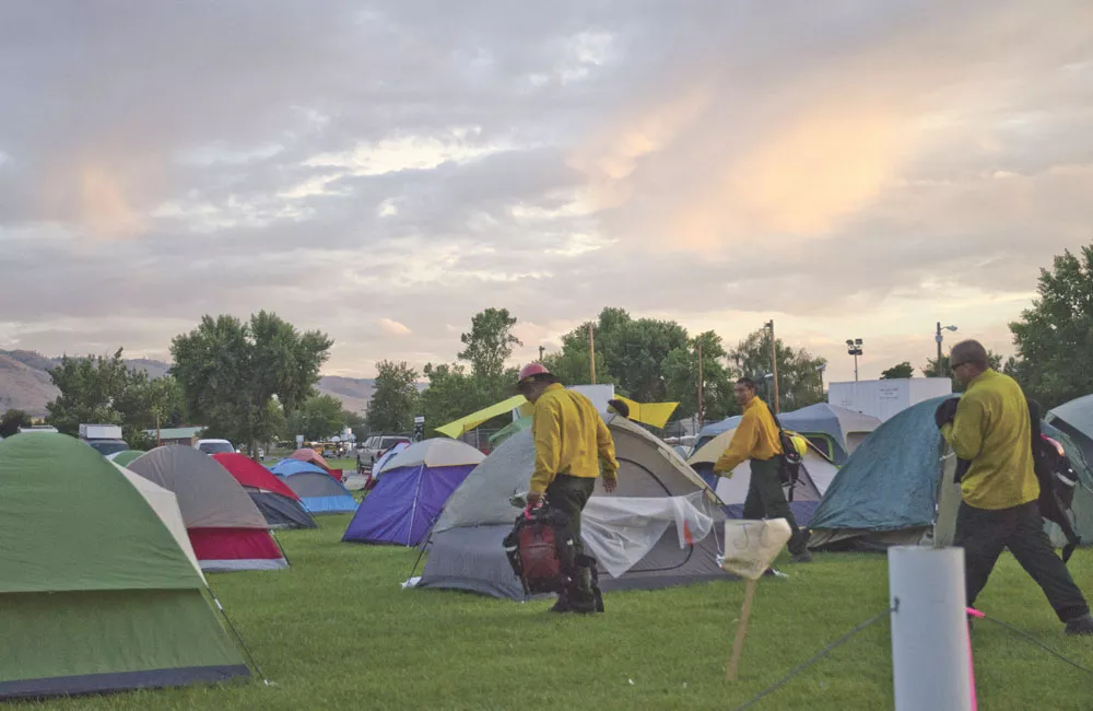 Dozens of tents shelter wildfire crews at a temporary fire camp at the Omak Stampede fairgrounds. - JACOB JONES
