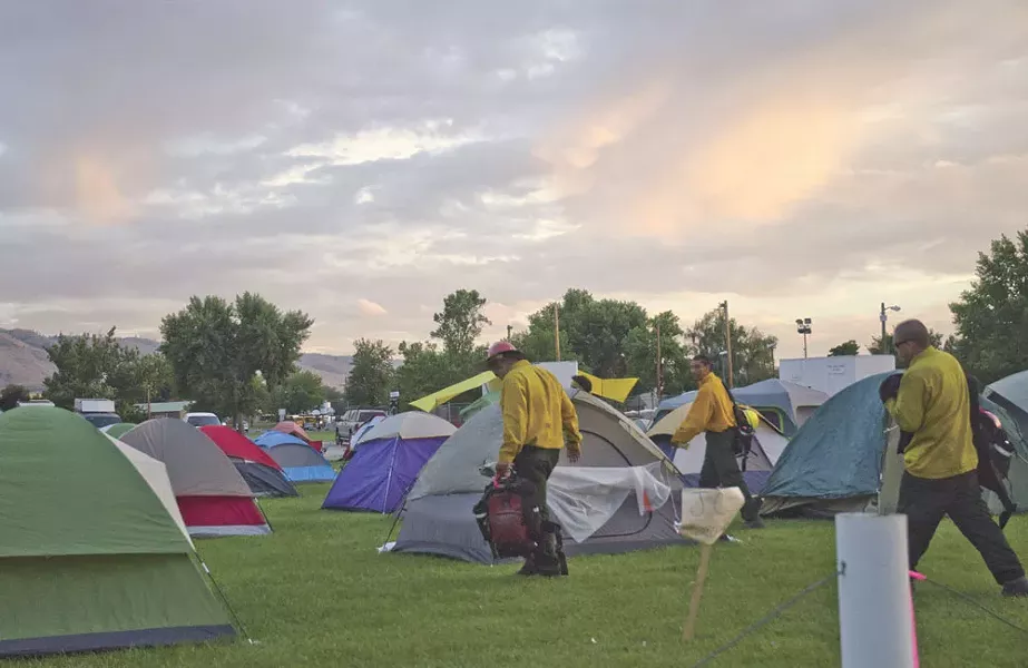 Dozens of tents shelter wildfire crews at a temporary fire camp at the Omak Stampede fairgrounds. - JACOB JONES