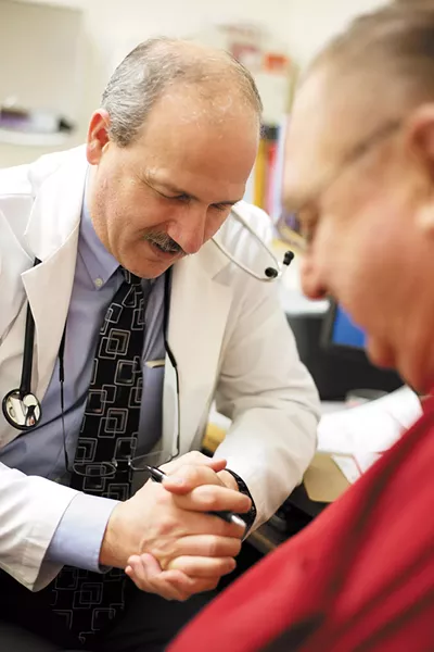 Dr. John Torquato prays with his patient, Gerben Roukema, at the Hayden Family Medical Care clinic. - YOUNG KWAK