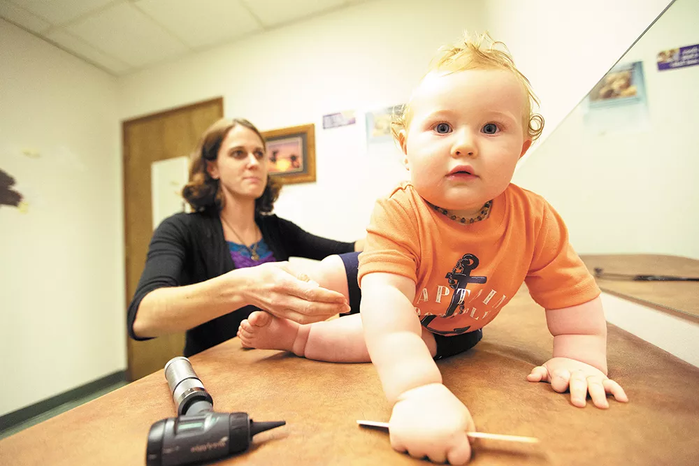 Eleven-month-old Beckett Smith crawls away during an exam with nurse practitioner Brooke Jordan. - YOUNG KWAK