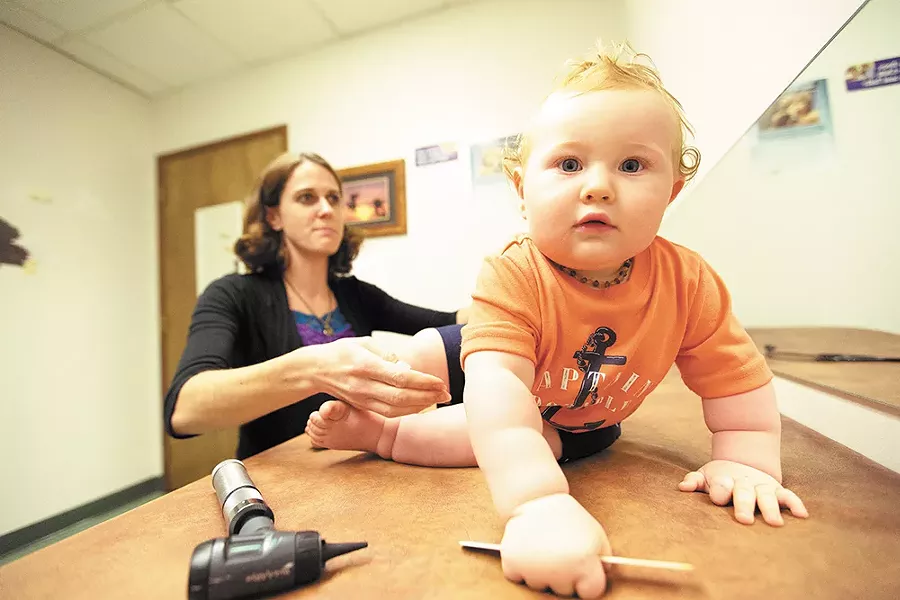 Eleven-month-old Beckett Smith crawls away during an exam with nurse practitioner Brooke Jordan. - YOUNG KWAK
