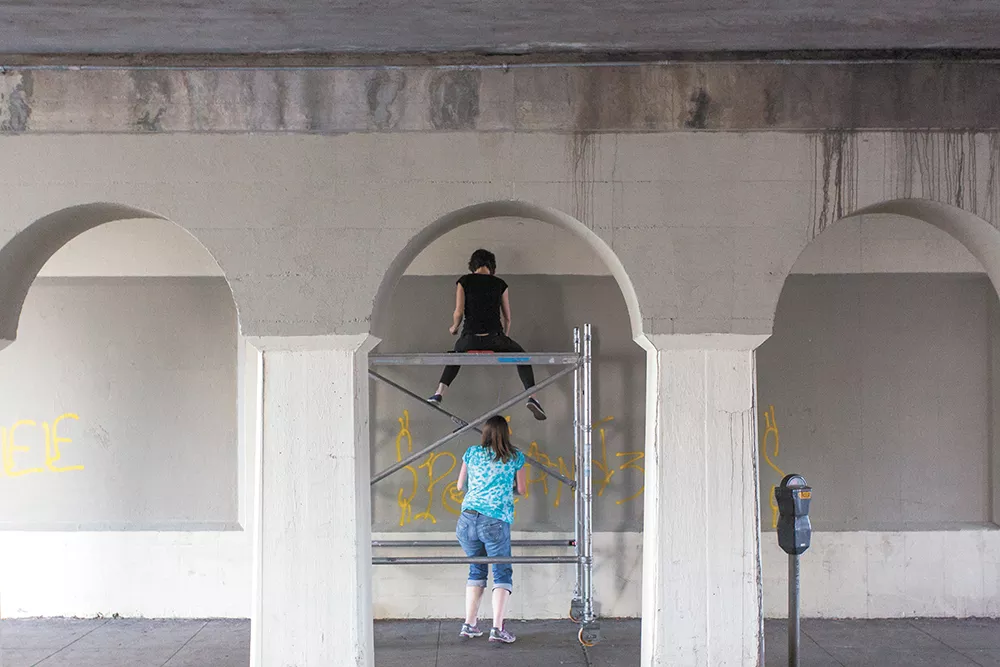 Ellen Picken (top) and Erin Mielcarek (bottom) begin work on their mural on Wall Street. - MATT WEIGAND