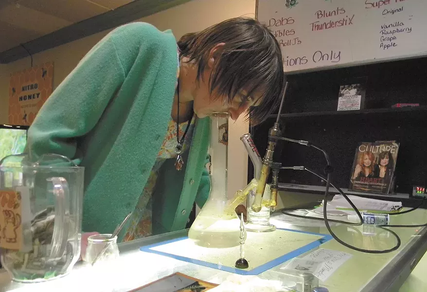 Erin Stone takes a dab hit from a vaporizer at the Members Lounge in Spokane Valley. - JAKE THOMAS