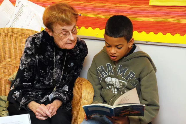 Esther Walter sits captivated by Dallas Winchester's reading at Hamblen Elementary in Spokane. - TAMMY MARSHALL