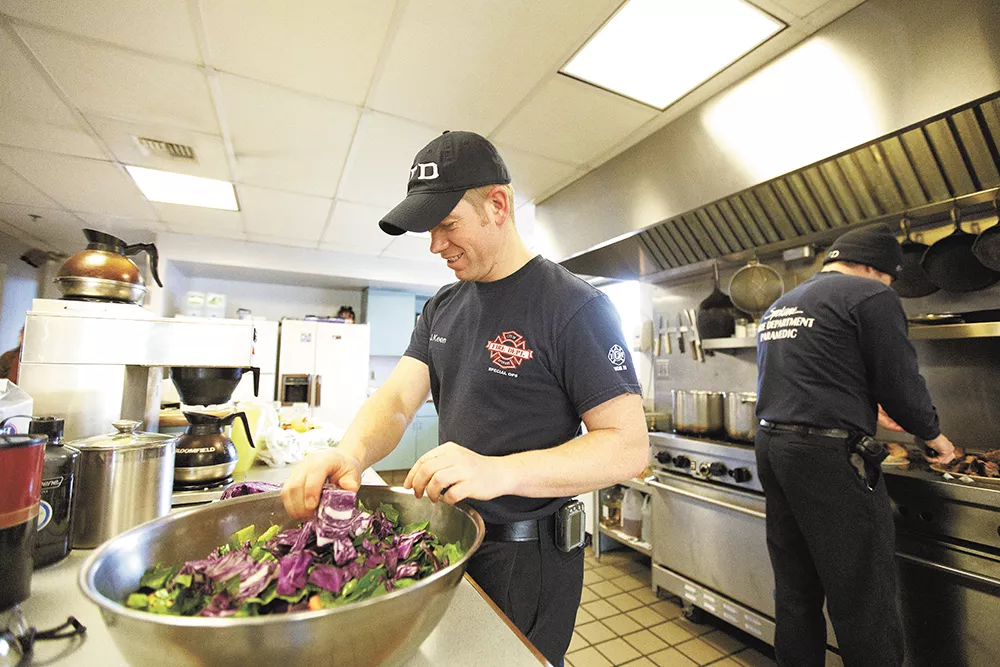 Firefighter Jason Keen (above) keeps it green with a big salad at Spokane Fire Station 2, while Capt. Don Waller (below) digs in. - YOUNG KWAK
