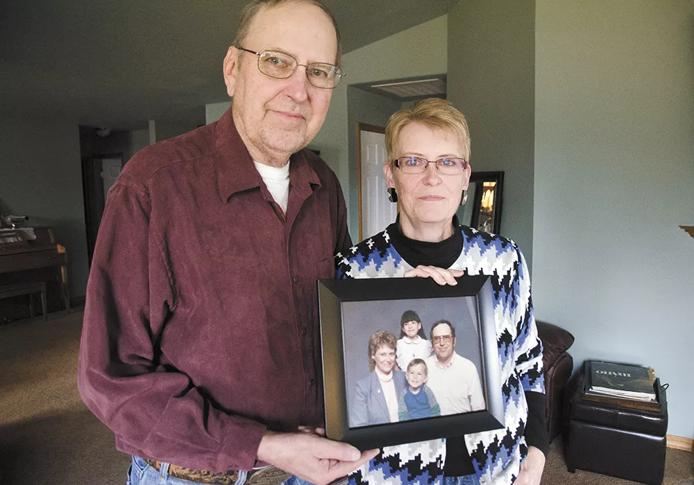 Geri and Sharon Johnson, of Spokane Valley, pose with a family photo of them with their son Aaron, who was shot multiple times by Spokane police on Jan. 16. - JACOB JONES