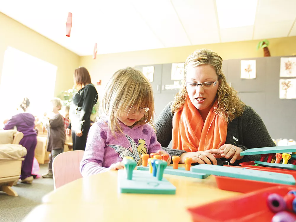 Head Start teacher Samantha Tuskan helps 3-year-old Tehya work on counting, color recognition and fine motor skills. - YOUNG KWAK