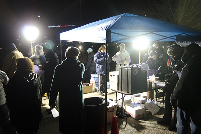 In predawn darkness, union members gather around a supply tent. - JACOB JONES