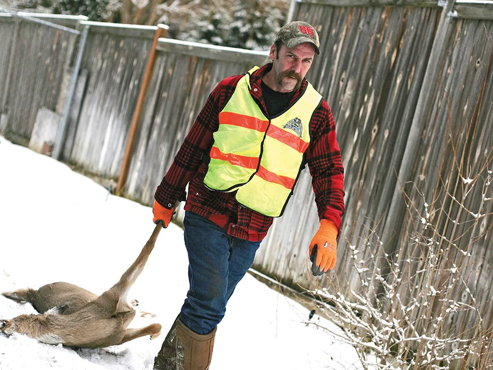 Inland Northwest Wildlife Council volunteer Rick Hedquist recovers a deer from a back yard in Spokane. - YOUNG KWAK