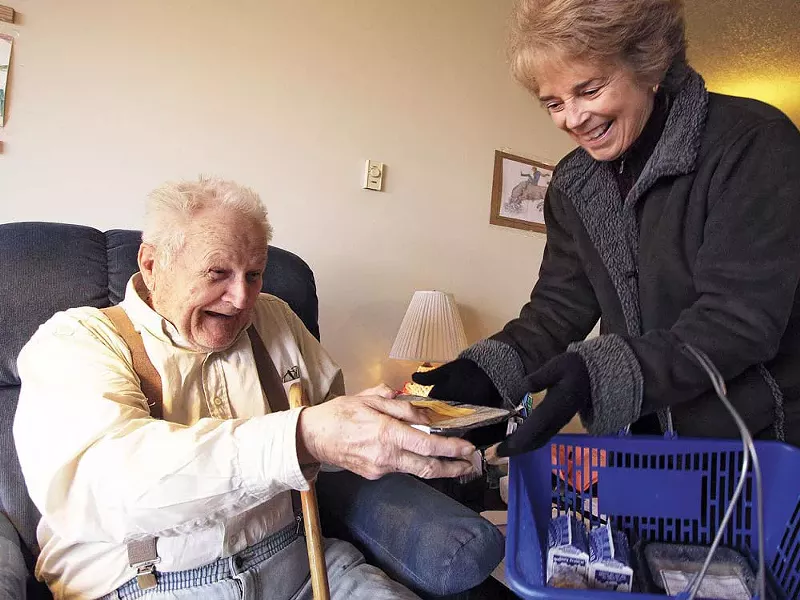 Judy Reilly, right, hands a Meals on Wheels delivery to 87-year-old Emanual Kennedy - YOUNG KWAK