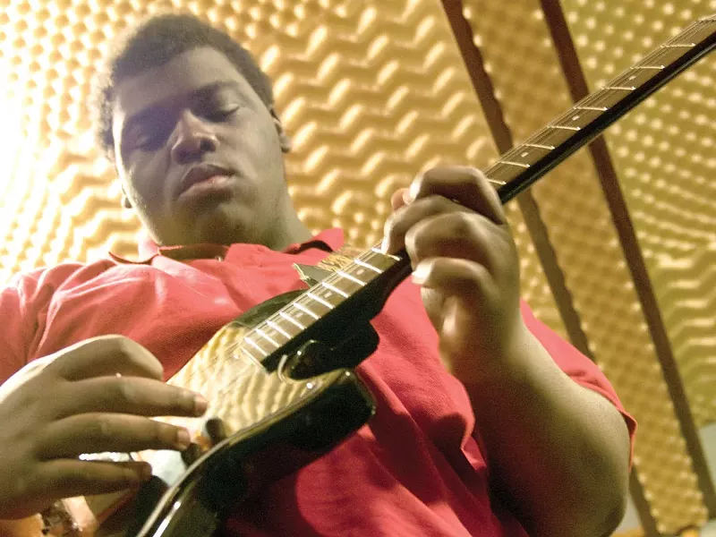 LeRon, 17, takes to the guitar during band practice at the Village Project studio. - AMY HUNTER