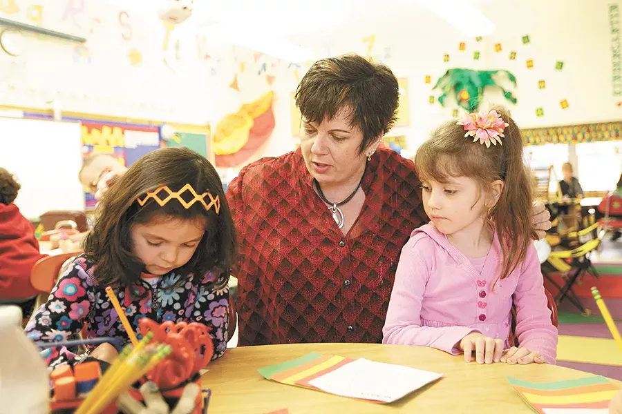 Madison Elementary kindergarten teacher Bambi Howe helps 5-year-olds Olivia Allen, left, and Vanessa Syrros with their writing assignments. - YOUNG KWAK