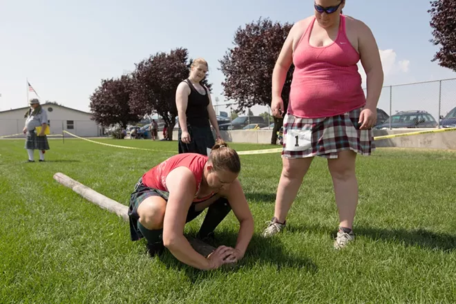 Maisie Walters, left, from Everett, Wash., shows proper caber toss technique to Spokanites Sandra Willmann, right, and Allison Hawn during the women's amateur A & B competition. - YOUNG KWAK