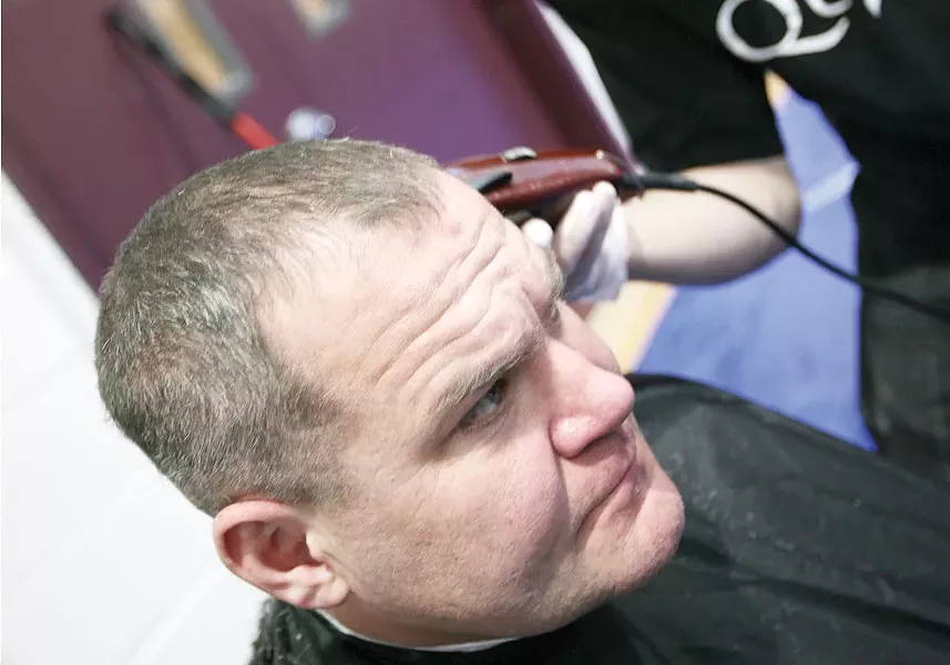 Mark Hunt receives a haircut from Quick\'s Barbershop at Emmanuel Family Life Center. - YOUNG KWAK