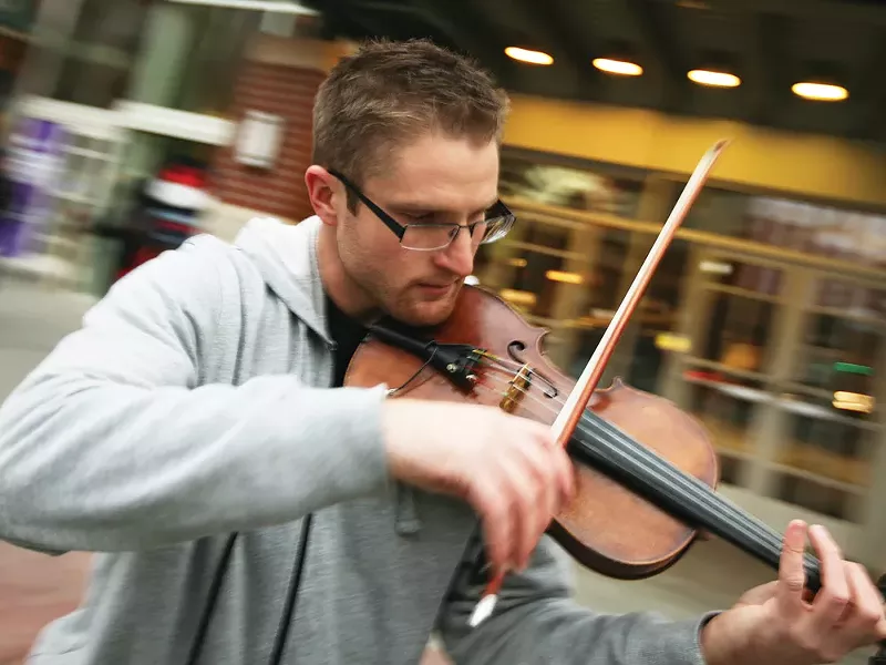 Michael Korpi, Jr. plays his violin to a crowd of busy shoppers. - YOUNG KWAK
