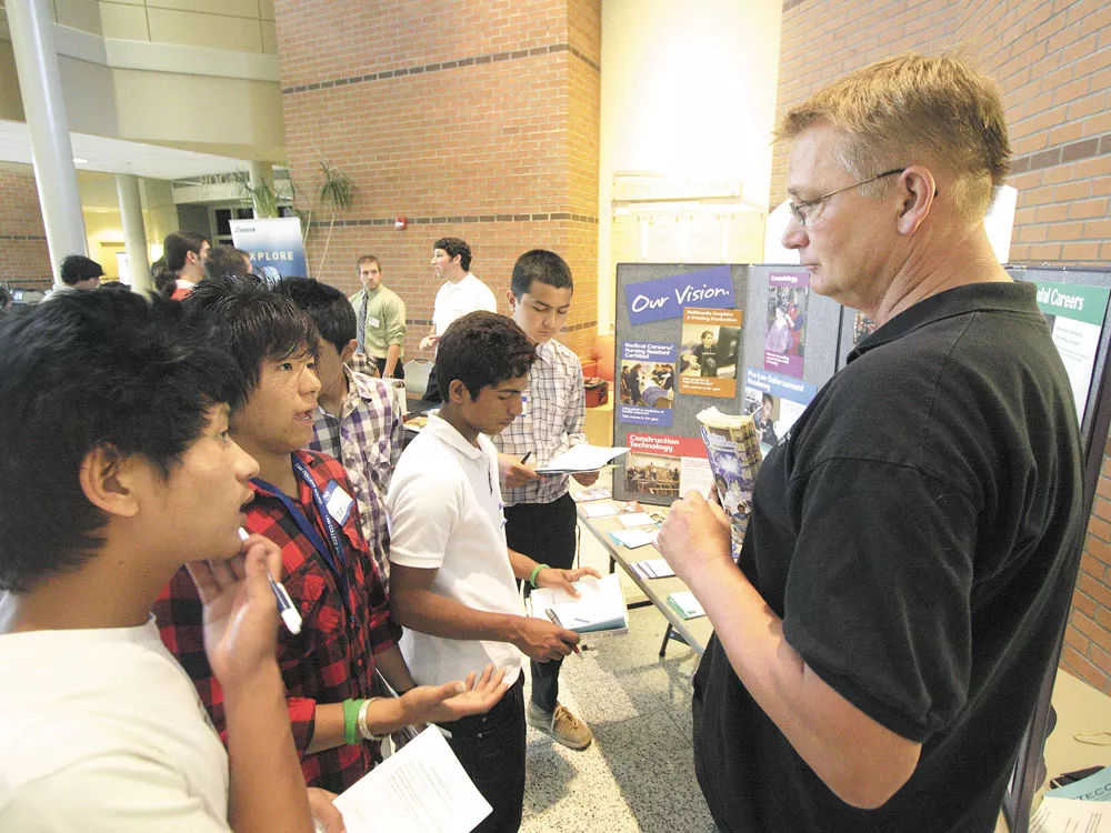Pranesh Rai, second from left, speaks to Scott Oakshott of the Spokane Skills Center - YOUNG KWAK PHOTO