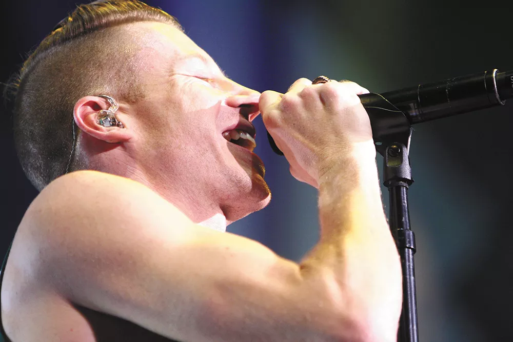 Rapper Macklemore gets up close and personal with his microphone during the sold-out Oct. 23 show at the Spokane Arena. - CHRIS BOVEY