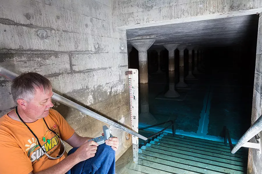 Reservoir provides welcome relief down a short flight of stairs. Inside lies 2 1/2 acres of concrete pillars and pristine drinking water on the eastern edge of Spokane’s South Hill. No one was allowed within three steps of the water in order to avoid any contamination. The city has in the past hired a specialized diver who would be bleached before entering the water to perform maintenance. Pictured is city employee Eric Schafer performing a weekly chlorine residual test. - STEPHEN SCHLANGE