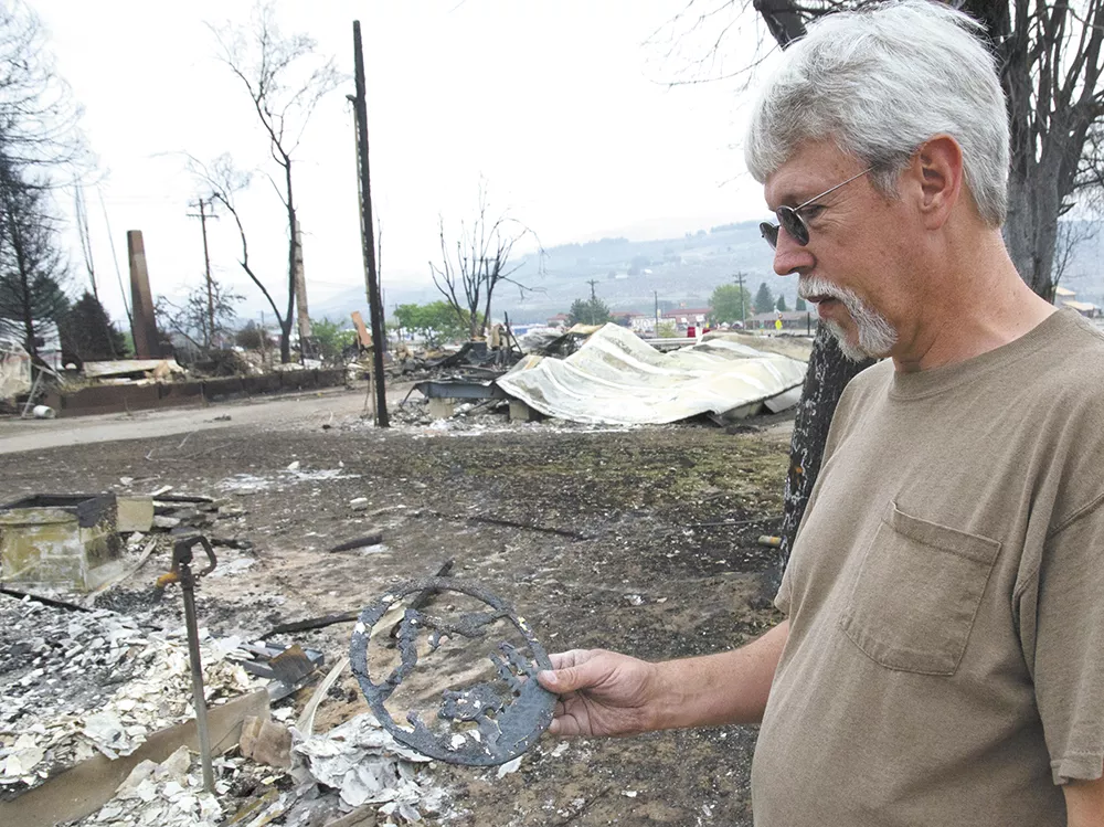 Richard Mathews inspects a decorative metal cutout his son made for him years ago. It’s the only keepsake that survived the fire. - JACOB JONES
