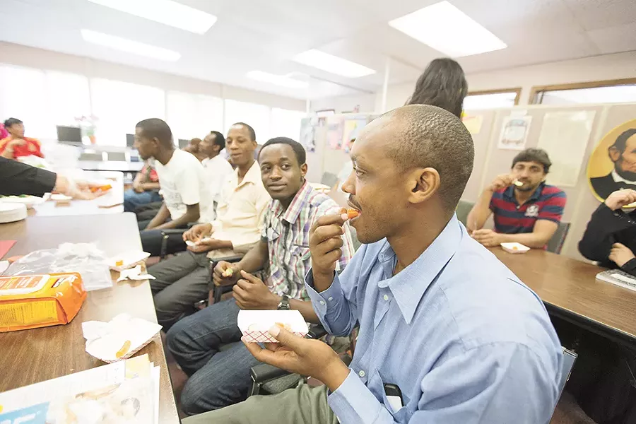 Rwandan refugee Emmanuel Rucyahana, right, tries a carrot during a nutrition workshop at World Relief Spokane. Funding for workshops like this one has been redirected to address immigration at the southern border. - YOUNG KWAK