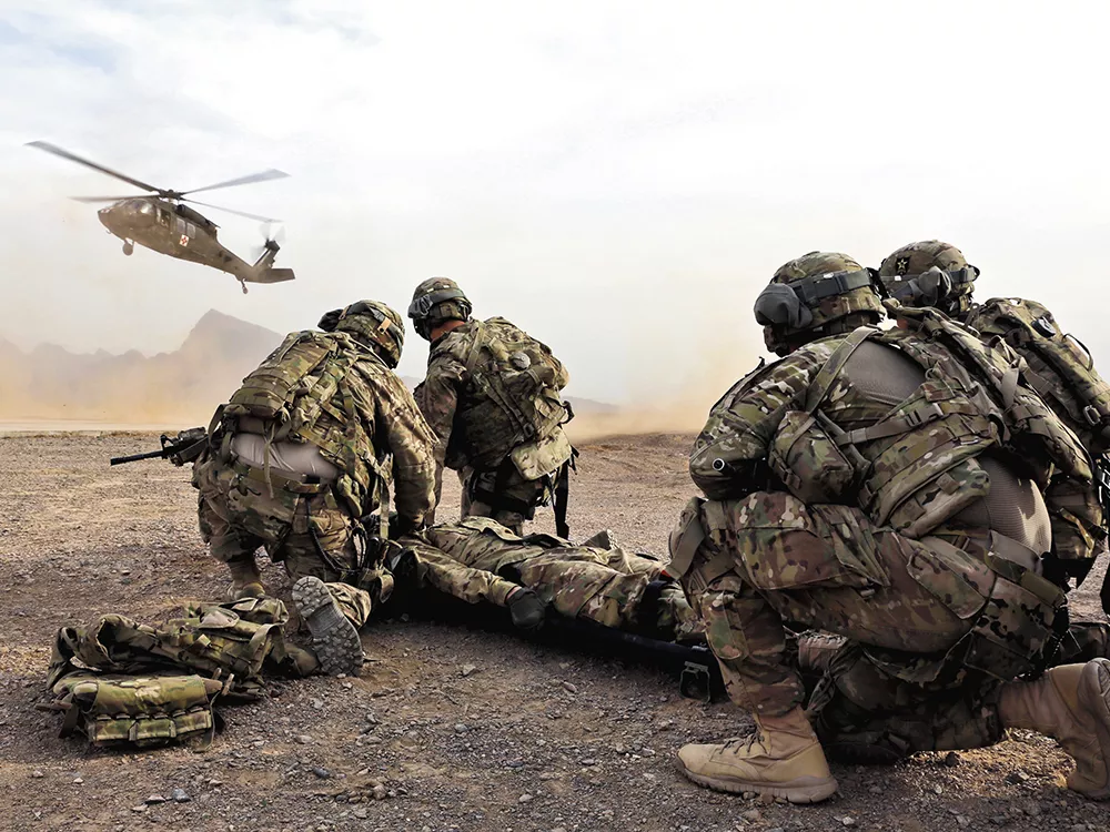 Soldiers in Afghanistan wait for a Black Hawk medevac helicopter to land before moving a simulated casualty during a training this month. - JOSH IVES
