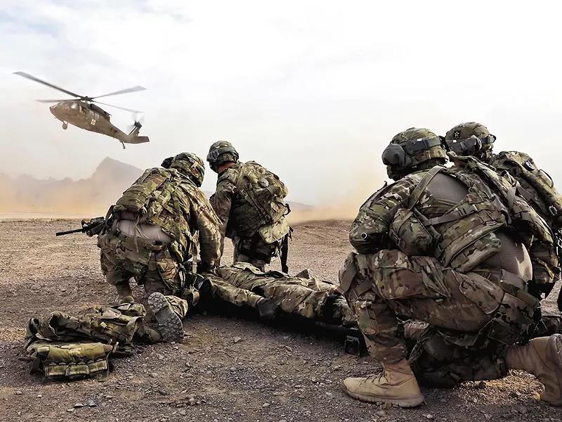 Soldiers in Afghanistan wait for a Black Hawk medevac helicopter to land before moving a simulated casualty during a training this month. - JOSH IVES