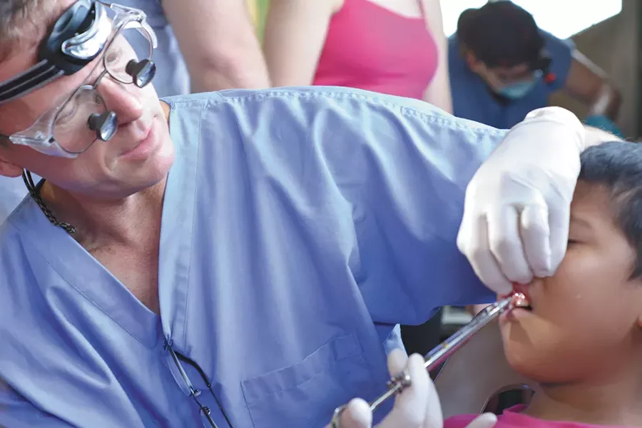 Steve Woodard numbs the gums of a Guatemalan girl. - CHRISTINE RUSHTON