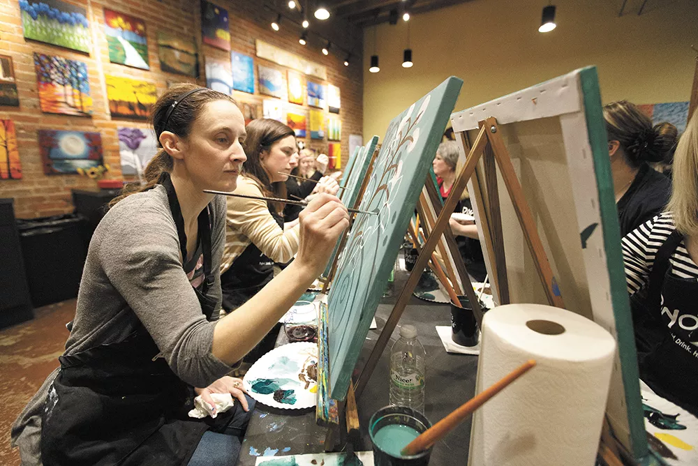 Student Lisa Mularski works on a painting, “Jasmine’s Jade,” during a class at Pinot’s Palette. - YOUNG KWAK
