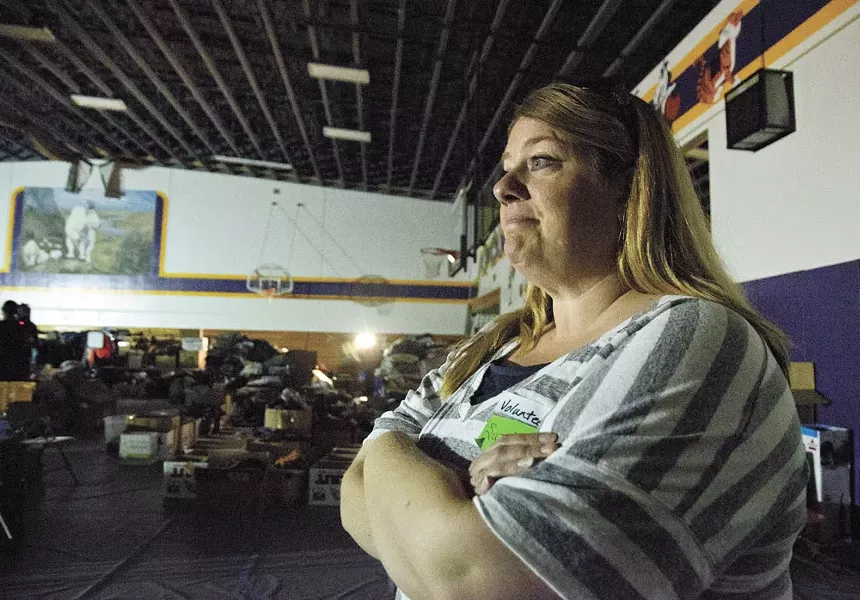 Suzette Ellis, a local relief volunteer, takes stock of the donations streaming into Pateros High School to help displaced residents recover from the fire. - JACOB JONES
