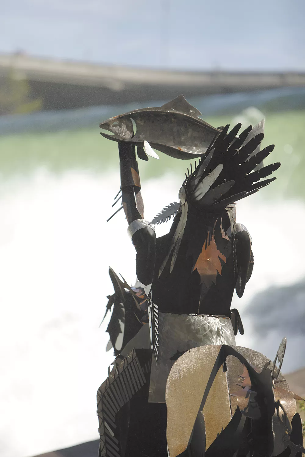 The Salmon Chief, located at Spokane's new Huntington Park along the lower falls of the Spokane River, raises a salmon to bless the river.