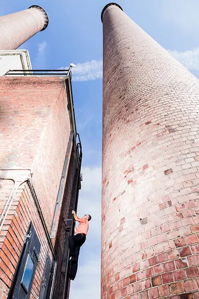 To access the top of the Steam Plant, you have to climb a ladder more than 90 years old. Here, Bill Bancroft, facilities operations manager, leads the way up. - STEPHEN SCHLANGE