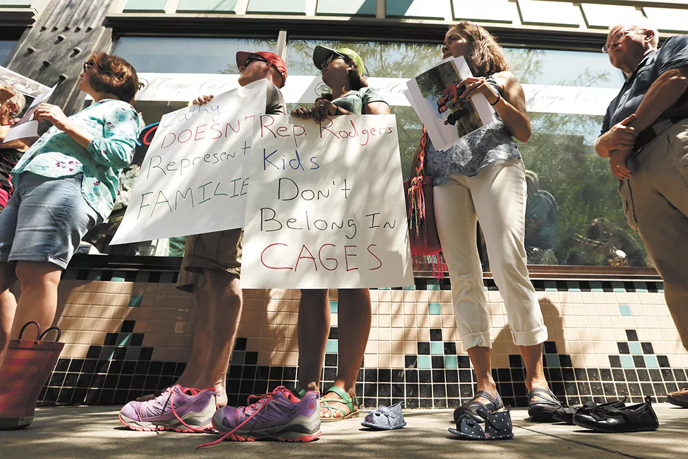 Protesters line up outside of Rep. Cathy McMorris Rodgers' office with tiny shoes representing immigrant children who have been separated from their families. - YOUNG KWAK