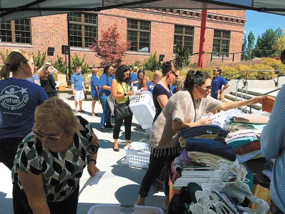 Volunteers help fill welcome baskets with household items for youth who got housed during the 100 Day Challenge in 2017. - SAMANTHA WOHLFEIL PHOTO