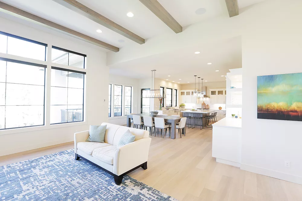 The airy Nickoloff home is grounded by black accents such as the geometric stair railing and Pella Architect Series contemporary windows; the wood floors are Lugano from DuChateau's Vernal Collection. The graceful iron ring chandelier is from Shades of Light. - YOUNG KWAK