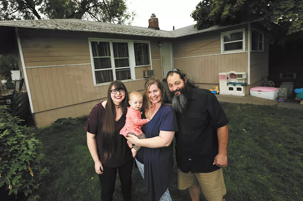 FROM RIGHT: William and Autumn Nixdorf, with daughters Avalynn (1) and Haley (17) in front of the home they saved from foreclosure. - YOUNG KWAK