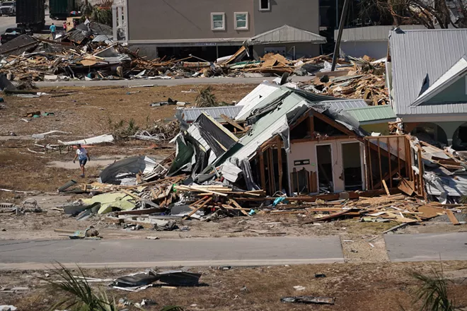 A woman cleans debris around a home in the aftermath of Hurricane Michael, in Mexico Beach, Fla., Oct. 13, 2018. By the end of this century, some parts of the world could face as many as six climate-related crises at the same time, researchers have concluded. - CHANG W. LEE/THE NEW YORK TIMES