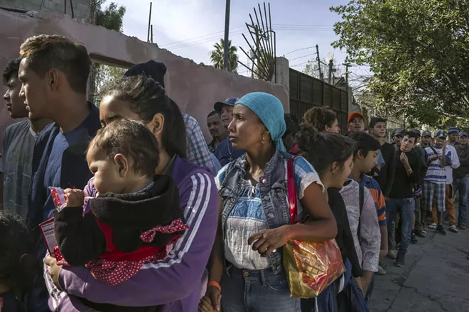 Melissa Guzmán, center, from Copán in Honduras, waits in line for food with other migrants outside a recently arranged shelter in Tijuana, Mexico, Nov. 17, 2018. A federal judge on Nov. 20 ordered the Trump administration to resume accepting asylum claims from migrants no matter where or how they entered the U.S., dealing at least a temporary setback to the president’s attempt to clamp down on a huge wave of Central Americans crossing the border. - MAURICIO LIMA/THE NEW YORK TIMES
