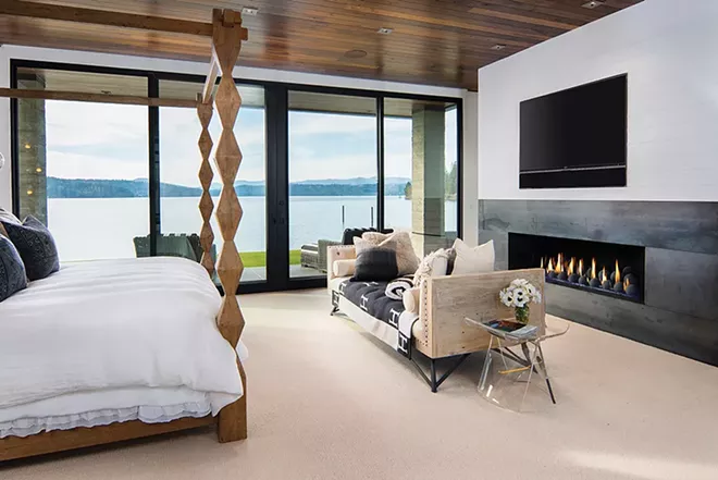 A dramatic fireplace complements expansive water views in this Coeur d'Alene master suite. - JOEL RINER PHOTO