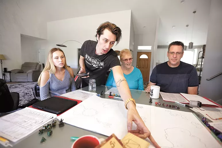 Dungeon master Josh Adrian, second from left, points out a spot on the game map to his sister Kayla (far left), grandmother Reggie Adrian and dad Joel Adrian. - YOUNG KWAK
