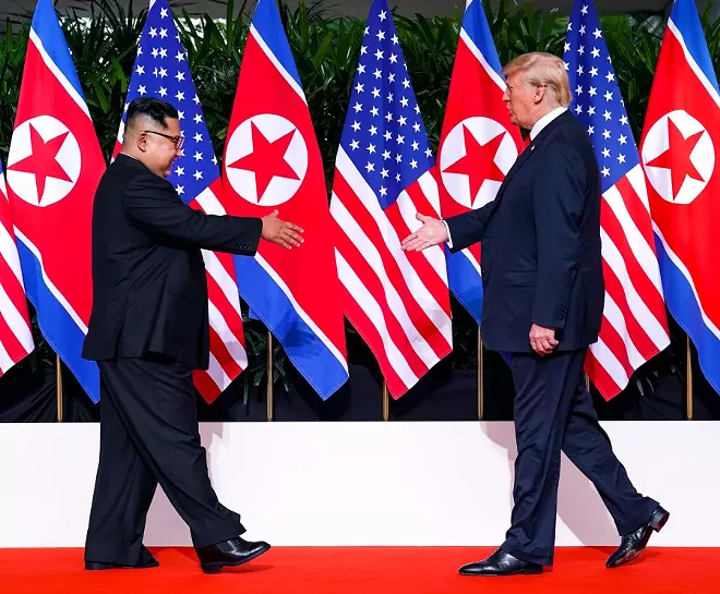 President Donald Trump and Kim Jong Un of North Korea greet each other before their meeting on Sentosa Island in Singapore, June 12, 2018. - DOUG MILLS/THE NEW YORK TIMES