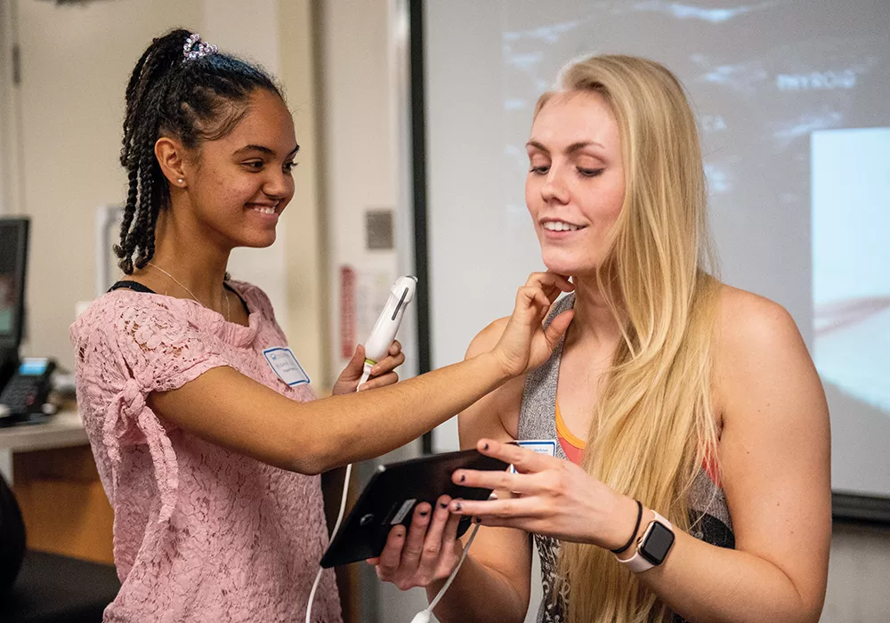 Brianna Vann, left, a junior at Rogers High School, learns to perform an ultrasound scan on Lauren Wells, a University of Washington medical student as part of the Med for Ed program. - UW SCHOOL OF MEDICINE PHOTO